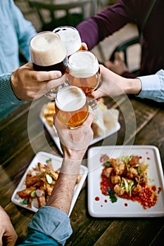 Drinking Beer. Friends Raising Glasses Of Beer