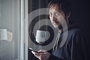 Drinking Coffee And Texting with Mobile Phone in Morning