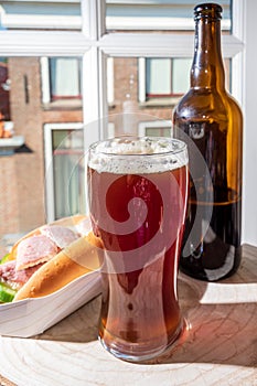 Drinking dark beer with smoked eel fish sandwich with view on street in old Zierikzee town, Zeeland, Netherland