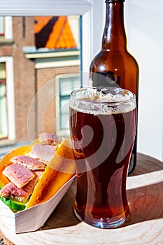 Drinking dark beer with smoked eel fish sandwich with view on street in old Zierikzee town, Zeeland, Netherland