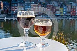 Drinking of dark and strong Belgian abbey beer with cheeses with nice view on Maas river and town Dinant, Belgium