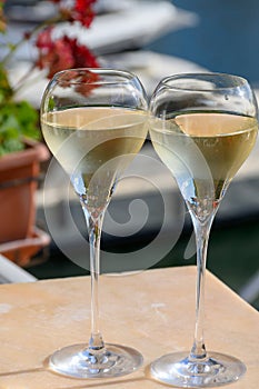 Drinking of French brut champagne sparkling wine in glasses, club party in yacht harbour of Port Grimaud near Saint-Tropez, French