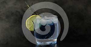 Drinking glass with cold drink. Refreshing soda lemonade blue cocktail