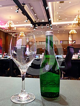 drinking glasses and green bottles on a gray table in the meeting room