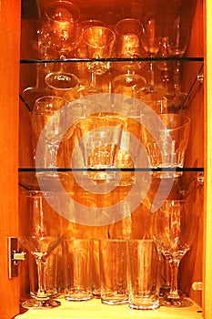 Drinking glasses inside a wooden cuboard.