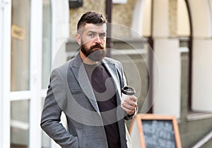 Drinking his cup first thing in the morning. Businessman in hipster style holding takeaway coffee. Hipster with