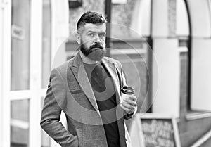 Drinking his cup first thing in the morning. Businessman in hipster style holding takeaway coffee. Hipster with