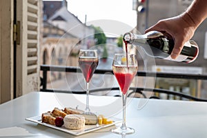 Drinking of Kir Royal,  French aperitif cocktail made  from creme de cassis topped with champagne, typically served in flute glass