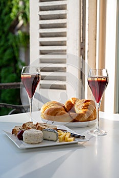 Drinking of Kir Royal,  French aperitif cocktail made  from creme de cassis topped with champagne, typically served in flute glass