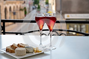 Drinking of Kir Royal,  French aperitif cocktail made  from creme de cassis topped with champagne, typically served in flute glass