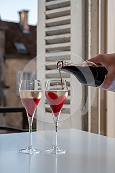 Drinking of Kir Royal,  French aperitif cocktail made  from creme de cassis topped with champagne, typically served in flute glass