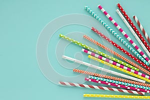 Drinking paper colorful straws for summer cocktails on light blue background.