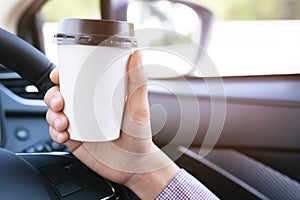 Drinking paper cup coffee of hot in hand while driving in a car