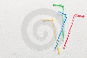 Drinking straws for party on Colored background. Top view of colorful plastic disposable straws for summer cocktails