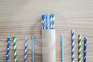 Drinking straws for party on woonden background. Top view of colorful paper disposable eco-friendly straws for summer cocktails