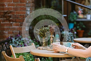 Drinking tea. woman holding cup of beverage while sitting at cafe.