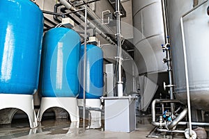 Drinking water factory or plant production, industrial interior. Large metal tanks for filtering and potable water