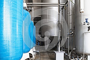 Drinking water factory or plant production, industrial interior. Large metal tanks for filtering and potable water