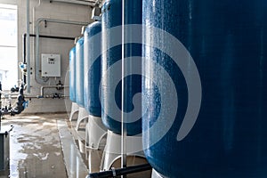 Drinking water factory or plant production, industrial interior. Large metal tanks for filtering and potable water