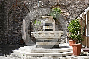 Drinking water fountain from marble with lion heads on a square in the old town of porto venere, liguria, italy