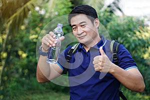 Drinking water for health. Asian man traveler holds bottle of drinking water