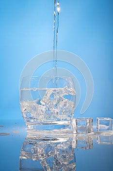 drinking water with ice on blue background