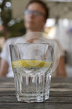 Drinking water with lemon and people in blur background