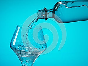 Drinking water is poured into a glass from a bottle