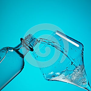 Drinking water is poured into a glass from a bottle