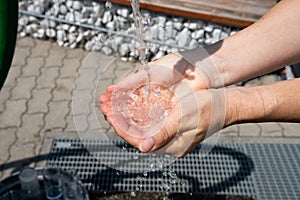 Drinking water puring into open palm