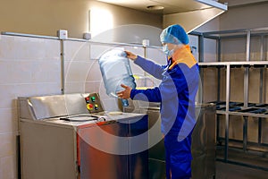 Drinking water treatment plant, factory worker inspect a plastic bottle, monitor cleanliness