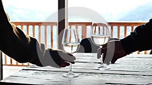 drinking wine.Glasses with wine in hands. Romantic dinner for two. Male and female hand take glasses of wine and clink