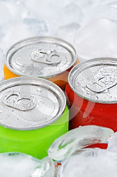 Drinks lemonade cola drink softdrinks in cans with ice cubes portrait format