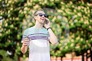 Drinks, technology and people concept - close up of businessman with coffee cup and smartphone on street