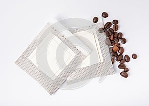 Drip bag of fresh coffee in a glass with coffee beans isolated on white background.