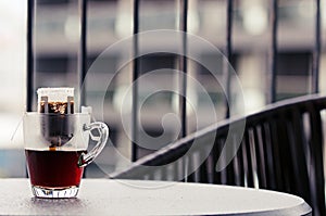 Drip or brewed coffee on wooden table, paper dripping bag on a cup