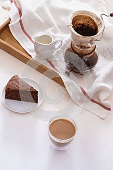 Drip coffee dripper and drip ground coffee with glass drip pot, cup and chocolate cake