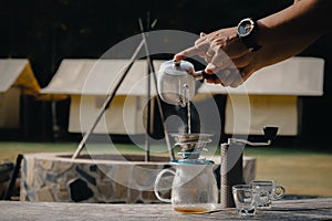 Drip coffee man pouring hot water on coffee ground with filter.