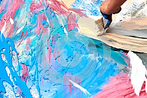 Drip painting expression art on canvas with blue, pink and beige colors, artist art performance