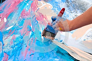 Drip painting expression art on canvas with blue, pink and beige colors, artist art performance