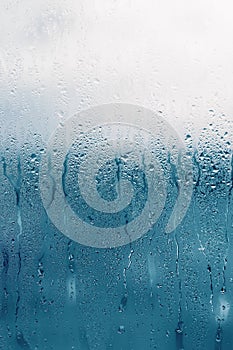 Dripping Condensation on the clear glass window. Water drops. Abstract background texture. Detail of moisture close up