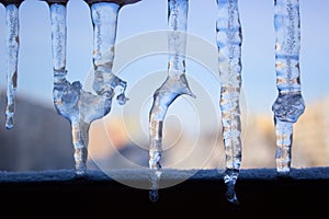 Dripping icicles against the sky. transparent icicle close up ag