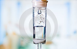 Dripping medical perfusion close up equipment in clinic background. Saline Solution IV Drip Fluid for Infusion in Hospital. Intrav