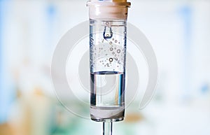 Dripping medical perfusion close up equipment in clinic background. Saline Solution IV Drip Fluid for Infusion in Hospital. Intrav photo