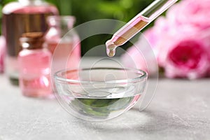 Dripping rose essential oil into bowl