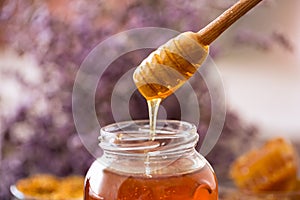 Dripping sweet golden honey from wooden dipper