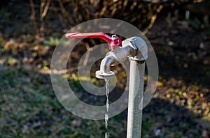 Dripping water from a garden water tap close up shot