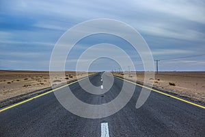 drive in desert on straight asphalt road idyllic simple wallpaper concept country side dramatic picture with cloudy weather and