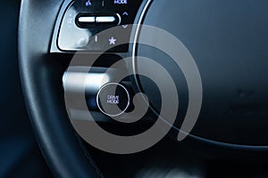 Drive mode button on luxury electric car dashboard. Relaxed and fuel efficient driving mode. Energy-saving button DRIVIE