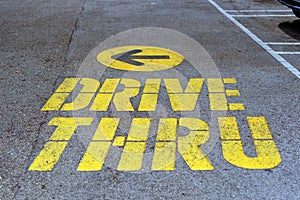 Drive thru traffic sign painted on yellow asphalt